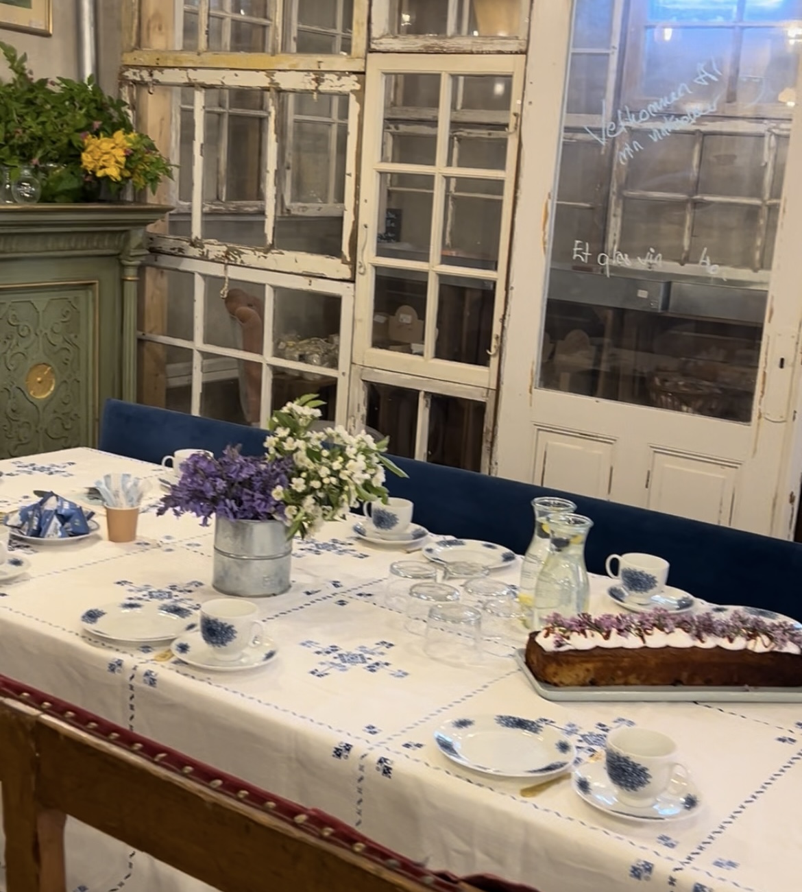Smukt opdækket bord med kage og blomster